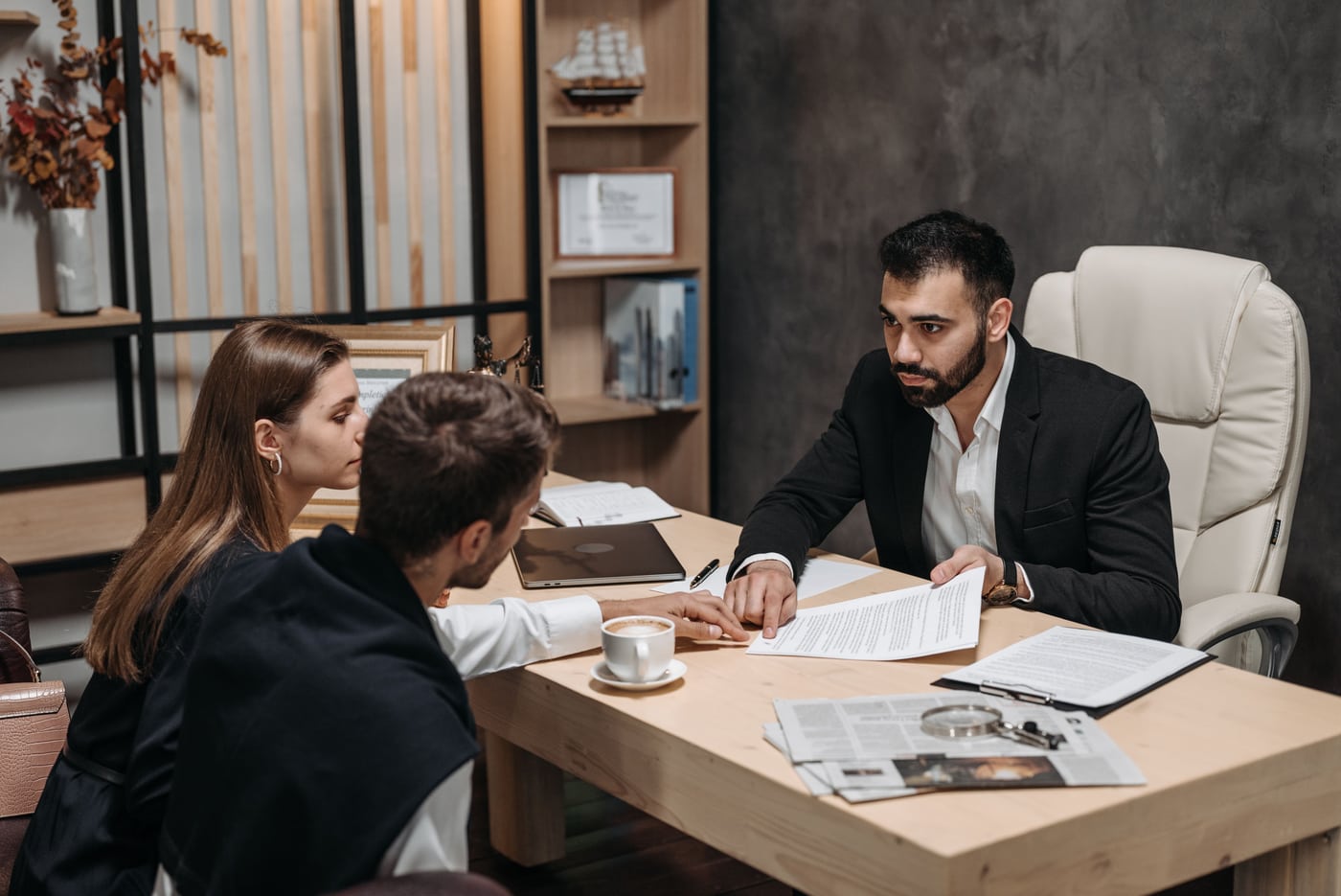 A lawyer reviewing documents with clients in an office.